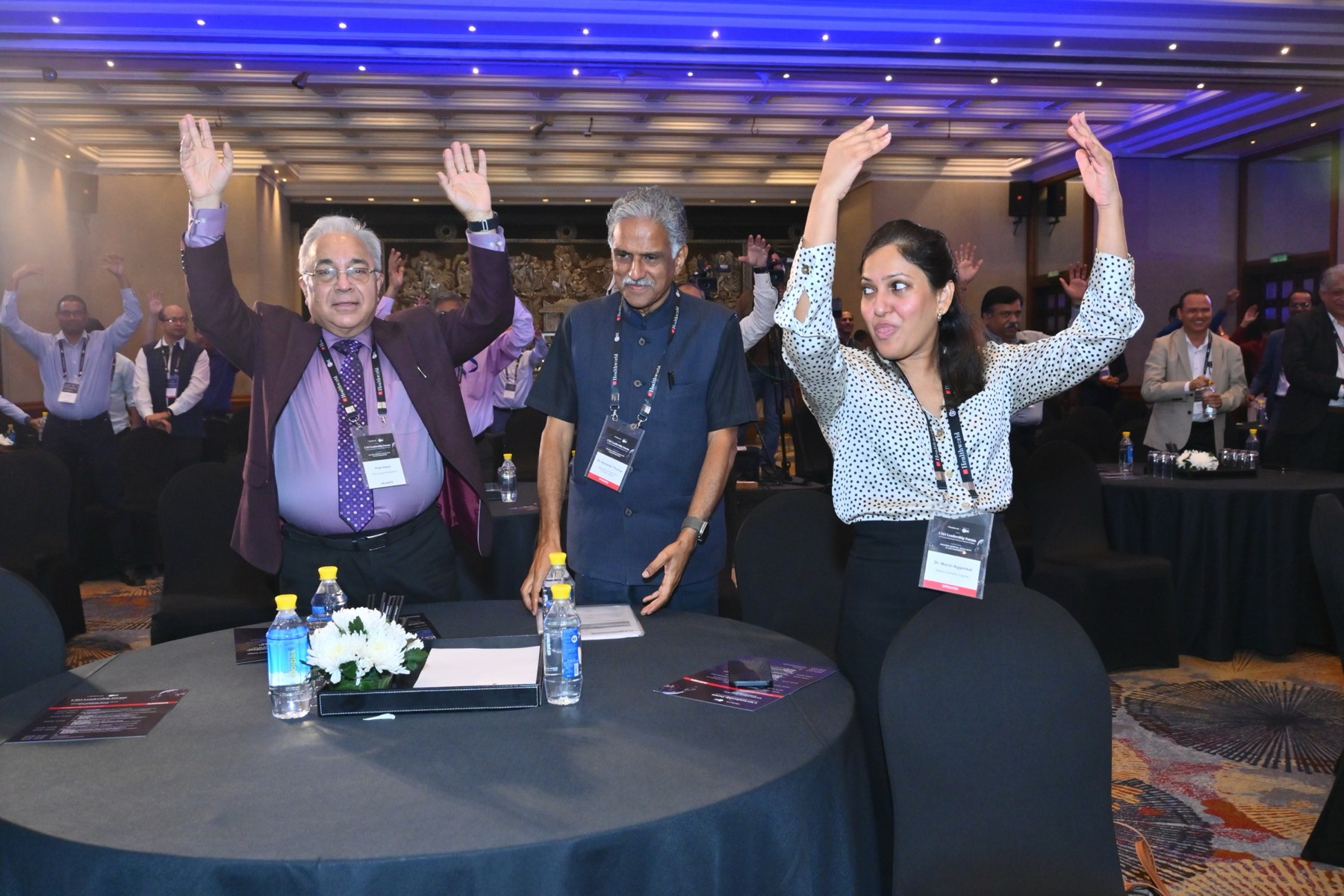 Attendees with hands raised during an audience moment.